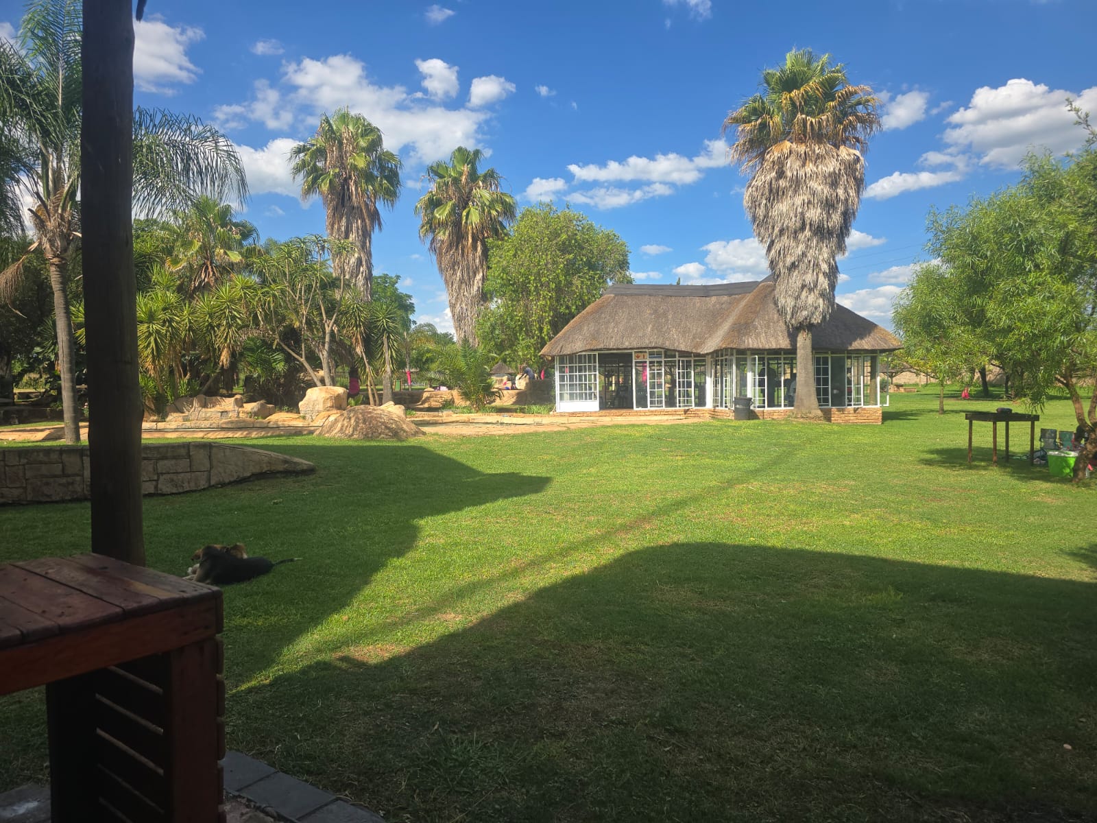 Glass-fronted thatched function building beside the lawn